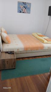 a bed sitting in a room with a wooden table at Privatni smeštaj Nanica in Mataruška Banja +8 photos