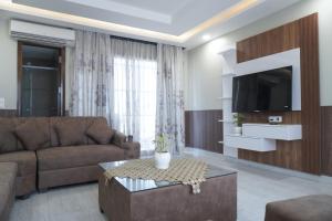 un soggiorno con un divano e una TV di Staybia Hotel and Service Apartments, Sector-27, Noida a Noida