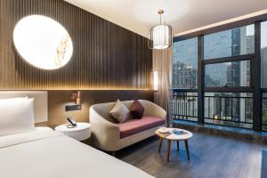 西安Xi 'an North Railway Station Municipal Government Orange Crystal Hotel的酒店客房设有床、沙发和窗户。