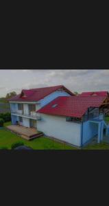 a house with a red roof on top of it at Sweet Dreams Apartment in Zator