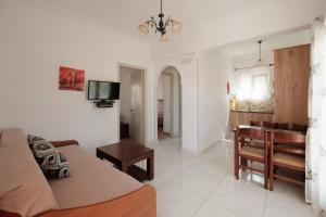 a living room with a couch and a table at Rainbow in Arillas