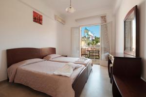 a bedroom with two beds and a dresser and a window at Rainbow in Arillas +46 photos