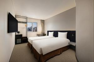 ソウルにあるibis Ambassador Seoul Insadong-Newly renovated in 2025のベッド2台とテレビがあるホテルの部屋