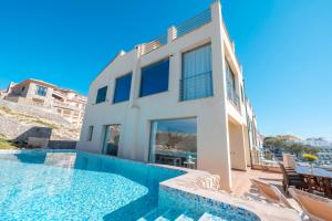 a villa with a swimming pool and a house at Cala Agulla 1 in Cala Ratjada