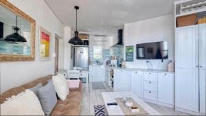 a living room with a couch and a kitchen at Klein-Hangklip Remote Mountain Studio Cottage in Rooiels