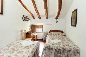 zwei Betten in einem Zimmer mit weißen Wänden in der Unterkunft Cortijo Rural Majolero 1 in Castillo de Locubín