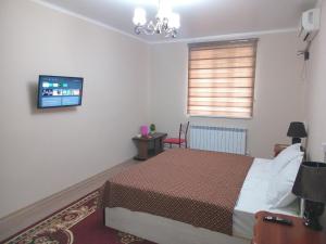 Un dormitorio con una cama y un televisor en la pared. en Full apartment in city center, en Khiva