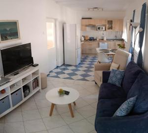 Una sala de estar con un sofá azul y un televisor en Sunny Family Apartment, en Gornji Karin