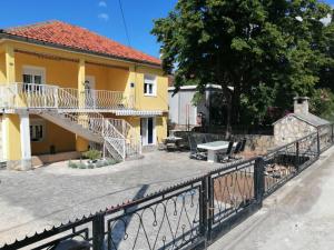 Casa amarilla con balcón y valla en Sunny Family Apartment, en Gornji Karin