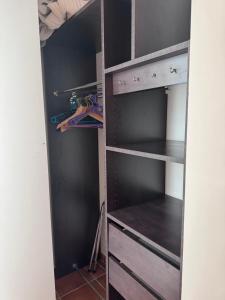 a closet with black shelves and wooden drawers at Domaine de la Fauvelle in Thuir