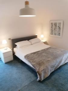 a bedroom with a large white bed and two lamps at Casa Gallina in Introdacqua