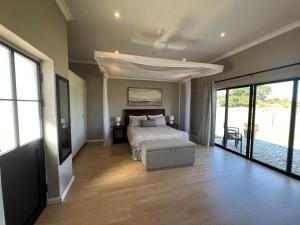 um quarto com uma cama, um sofá e janelas em Sunset Field Guest Flat em Kabwe