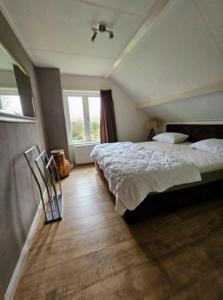 a bedroom with a large bed and a window at Tuyn van Zeeland in Nieuwerkerk