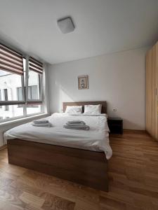 une chambre avec un grand lit avec des draps blancs dans l'établissement Nyvky Like Home - Good for family 63, à Kiev