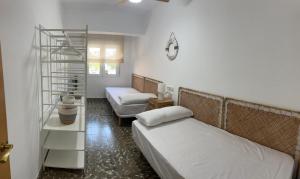 ein Schlafzimmer mit 2 Betten und einem Bücherregal in der Unterkunft Amplio apartamento cerca al mar in Puerto de Sagunto
