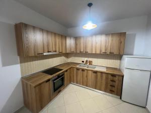 eine Küche mit Holzschränken und einem weißen Kühlschrank in der Unterkunft Bloom Haven in Kashari
