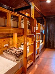 a room with bunk beds in a log cabin at Nezer Hostel & Roof Top Cafe in Leh