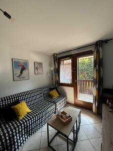 Una sala de estar con un sofá blanco y negro y una mesa. en Appartement tout confort centre, en Arâches-la-Frasse 13 fotos más