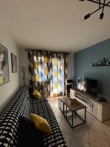 Un dormitorio con una cama, una mesa y un televisor. en Appartement tout confort centre, en Arâches-la-Frasse