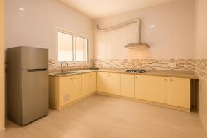 a kitchen with a refrigerator and a sink at Cosy Residence Amira in Monastir