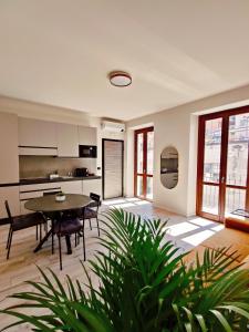 a living room with a table and a kitchen at La Morra Apartments in La Morra