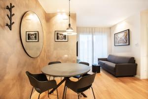 een woonkamer met een tafel en een bank bij Emerald Living Merlata in Pero
