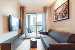 een woonkamer met een bank en een groot raam bij Emerald Living Merlata in Pero