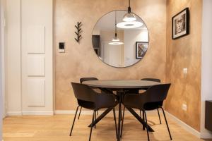 een eetkamer met een tafel en een spiegel bij Emerald Living Merlata in Pero +25 foto's
