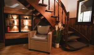 a living room with a chair and a staircase at Noclegi in Ruda Śląska
