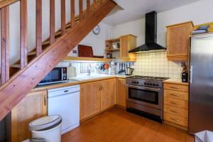eine Küche mit Holzschränken und einer Treppe in der Unterkunft Le Sivelou - Gîte 9 personnes in Saint-Félix-de-Pallières