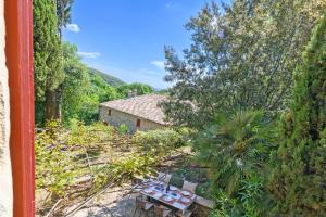 einen Blick über eine Terrasse mit einem Tisch und Stühlen in der Unterkunft Le Sivelou - Gîte 9 personnes in Saint-Félix-de-Pallières
