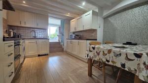 a kitchen with a table with a table cloth on it at Talarfor Barmouth in Barmouth