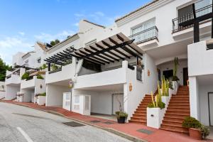 Una hilera de edificios de apartamentos blancos en una calle en Casa Istan, en Istán