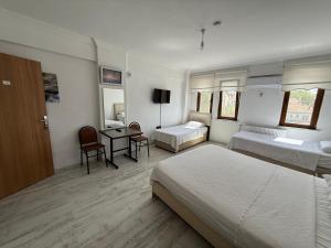 a hotel room with two beds and a desk at FAMİLY PLAs HOME in Edirne