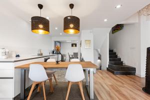 cocina y comedor con mesa de madera y sillas blancas en Casa Istan, en Istán