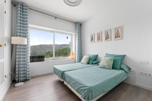 un dormitorio con una cama y una ventana en Casa Istan, en Istán