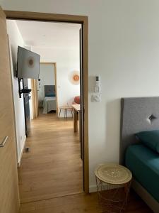 a room with a bed and a hallway with a mirror at Appartement F3 Corte, centre ville in Corte