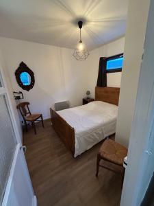 a bedroom with a bed and a chair and a window at Maison Algus in Cucq