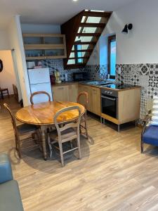 a kitchen with a wooden table and a dining room at Maison Algus in Cucq