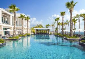 una piscina con palme e un edificio di Amavi, MadeForTwo Hotels - Paphos a Paphos