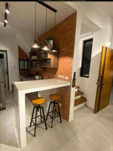 a kitchen with two bar stools and a counter at Amazing 4 bedroom Home in Batangas City +8 photos