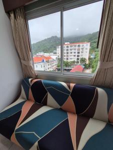 a couch sitting in front of a window at New Forest Patong in Patong Beach