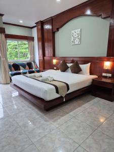 a bedroom with a large bed with a wooden headboard at New Forest Patong in Patong Beach