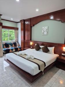 a bedroom with a large bed and a couch at New Forest Patong in Patong Beach