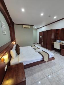 a bedroom with a large bed and a desk at New Forest Patong in Patong Beach