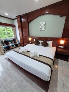 a bedroom with a large bed with a wooden headboard at New Forest Patong in Patong Beach