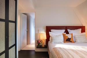 a bedroom with a bed with white sheets and pillows at Hotel La Villa Saint Germain Des Prés in Paris