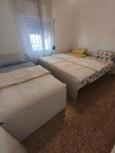 a bedroom with two beds and a window at Casa en la montaña con jacuzzi exterior y piscina in Alcántara de Júcar +12 photos