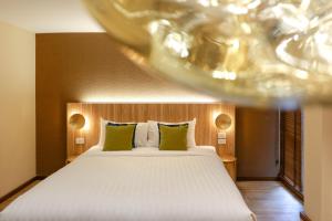 a bedroom with a large white bed with green pillows at Mybed Chonburi in Ban Nong Tako