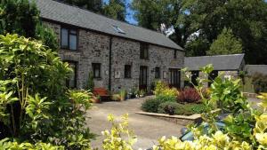 una casa in mattoni con giardino di fronte di Petrock Holiday Cottages a Newton Saint Petrock
